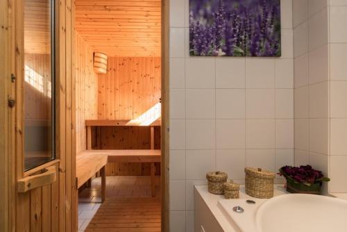 a bathroom with a tub and a sink at B en B En Route in Berg en Terblijt