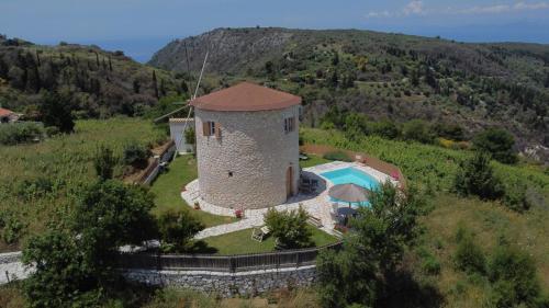 einem Luftblick auf ein Gebäude mit einem Pool in der Unterkunft Anemomilos Villa in Asprogerakata