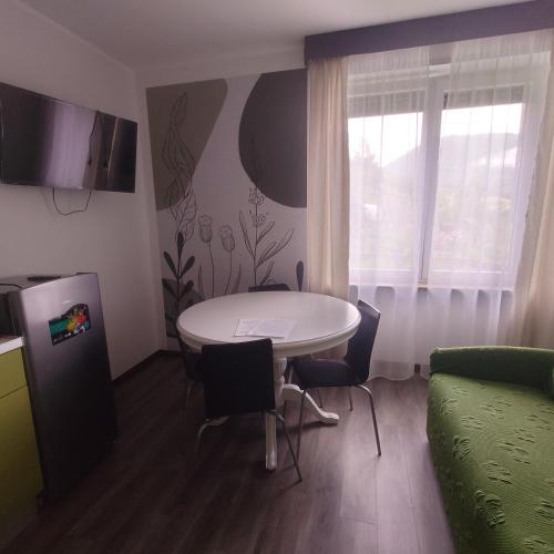 una pequeña sala de estar con mesa y sillas. en appartamento 'Il glicine' en Valli del Pasubio