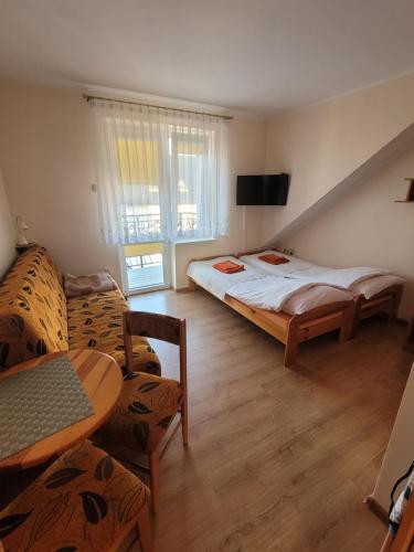 カルビアにあるPokoje goscinne Haniaのベッドルーム1室(ベッド2台、テーブル、ソファ付)
