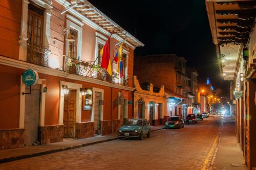 une rue la nuit avec des voitures garées dans la rue dans l'établissement Hotel Campanario, à Cuenca