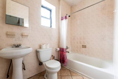 a bathroom with a toilet and a sink and a tub at Cozy Apt 3BR/2Baths in NYC in New York