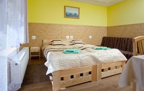 1 dormitorio con 1 cama grande y pared amarilla en Pensjonat Borowik, en Jelenia Góra-Jagniątków