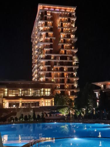 a hotel with a swimming pool in front of a building at Luxury Dreamland Oasis Apartments in Chakvi