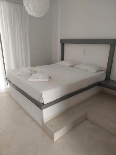 a bed with white sheets and white towels on it at Golden Star Praxitelous in Agia Marina Aegina