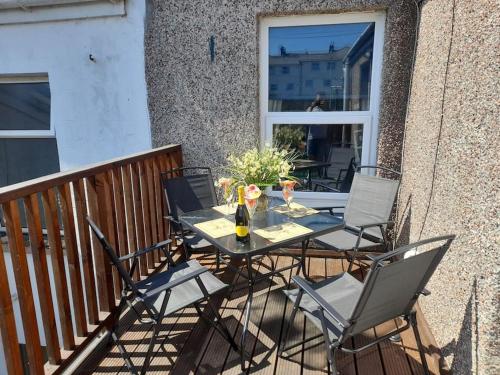 a table and chairs on the balcony of a house at Plymouth Professionals Apartment in Plymouth