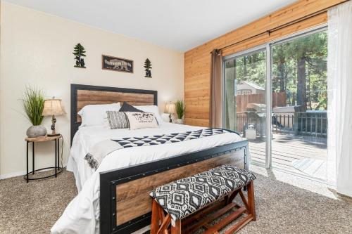 een slaapkamer met een groot bed en een balkon bij The Twisted Twig - Great amenities! Patio Deck for nights under the stars & trees, and Hot Tub! in Big Bear Lake