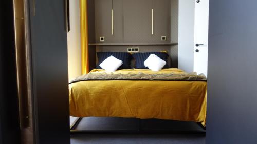 um quarto com uma cama amarela e 2 almofadas em Middelburg Koperwiek em Middelburg
