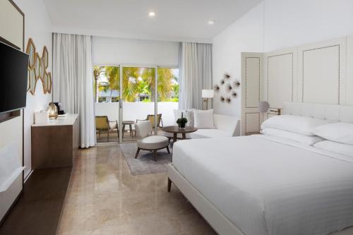 a white bedroom with a bed and a living room at Hyatt Regency Grand Reserve Puerto Rico in Rio Grande