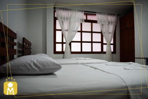 1 dormitorio con 2 camas y ventana en HOTEL MONTERREY, en Mocoa