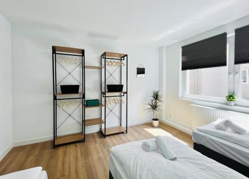 Cette chambre comprend 2 lits et des étagères. dans l'établissement Sali - R6 - Apartmenthaus, WLAN, TV, à Remscheid