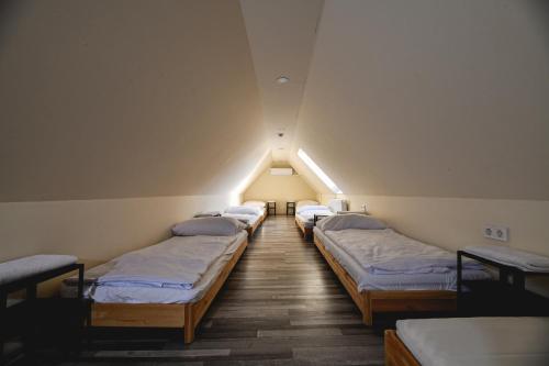 szereg łóżek w pokoju na poddaszu w obiekcie Végvári Hotel Eger w Egerze