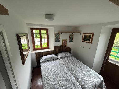 niewielka sypialnia z łóżkiem i 2 oknami w obiekcie Abetone Pian di Novello - trekking hut w mieście Pian di Novello