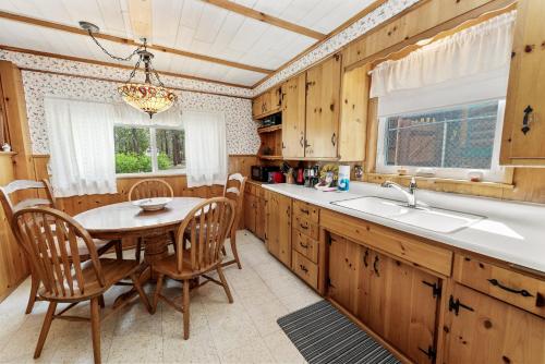 een keuken met een tafel en stoelen en een wastafel bij The Petite Cabin - Rustic and Cozy! Perfect place to unwind and relax! Close to Village in Big Bear Lake