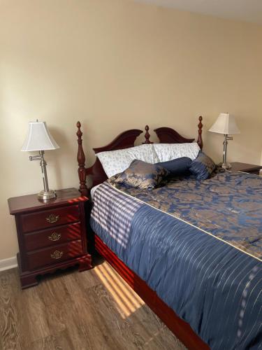 1 dormitorio con 1 cama y mesita de noche con 2 lámparas en Quiet 2 Bedroom Apartment Condo in the Hampden / Medfield area few minutes to Downtown - Emerald Elite en Baltimore