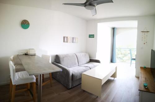 un salon avec un canapé et une table dans l'établissement Appartement avec piscine et garage proche plage et commerces, à La Seyne-sur-Mer