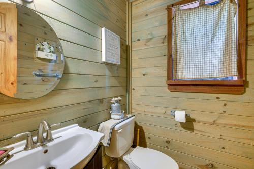 ein Badezimmer mit einem Waschbecken, einem WC und einem Spiegel in der Unterkunft Cape Royale Luxury Livingston Cabin with Hot Tub! in Coldspring