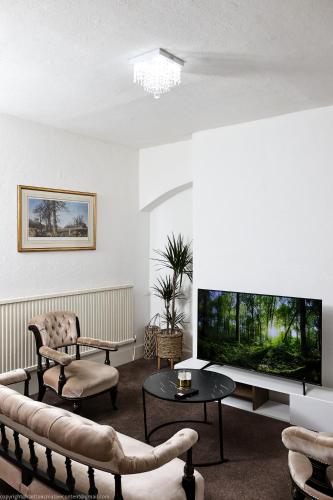 a living room with a large flat screen tv at The Water Works Cottage in London