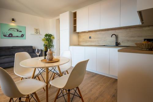 eine Küche und ein Wohnzimmer mit einem Tisch und Stühlen in der Unterkunft Lea Apartments in Drage