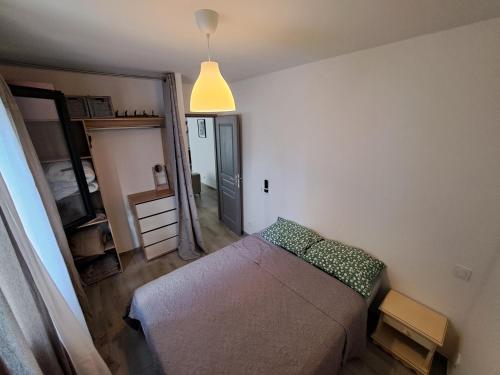 um pequeno quarto com uma cama e um espelho em Charmante Maison avec Piscine em Bessan