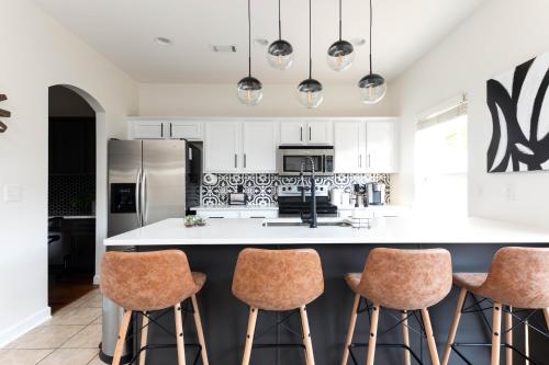 a kitchen with white cabinets and a island with bar stools at Relax in Style Near the Heart of Music City in Nashville