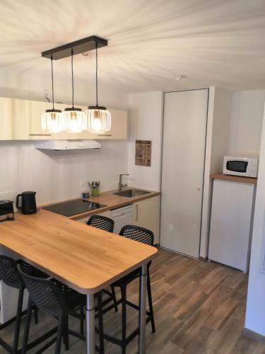 - une cuisine avec une table et des chaises en bois dans la chambre dans l'établissement Appartement neuf 40 m² 300 m de la mer, à Saint-Jean-de-Monts