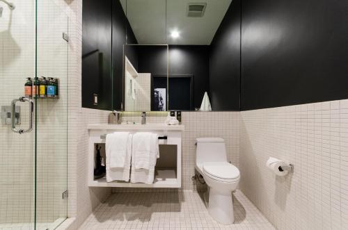 La salle de bains est pourvue de toilettes, d'un lavabo et d'une douche. dans l'établissement Audemar Boutique Hotel and Apartment Homes, à Los Angeles