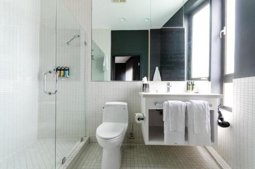 La salle de bains est pourvue de toilettes, d'un lavabo et d'une douche. dans l'établissement Audemar Boutique Hotel and Apartment Homes, à Los Angeles