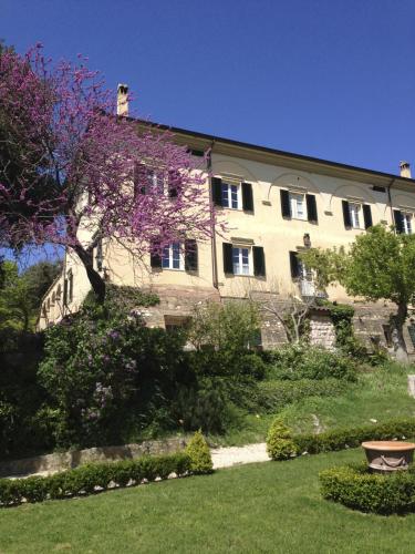 a large building with purple flowers in front of a yard at La Ghirlanda Wine Resort in Saragano