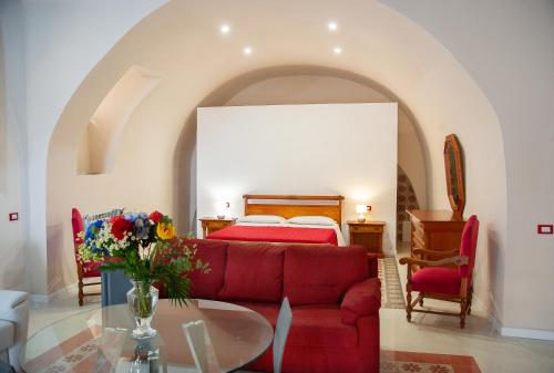 um quarto com um sofá vermelho e uma cama em PALAZZO ZUPPARDO LUXURY em Agrigento