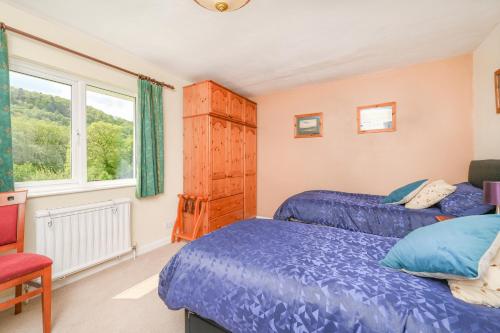 a bedroom with two beds and a window at Riverside B&B in Moretonhampstead