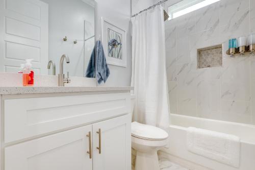 a white bathroom with a sink and a toilet at Bright Foley Home with Patio - 7 Mi to Wharf and Beach in Foley
