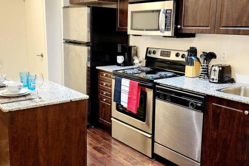 a kitchen with a stainless steel stove and microwave at Lakeview Condo in Downtown with Free Parking. in Toronto