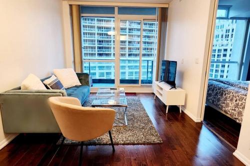 een woonkamer met een bank, een tafel en een bed bij Lakeview Condo in Downtown with Free Parking. in Toronto