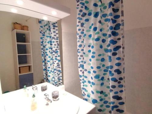 a bathroom with a sink and a shower curtain at Appartement de charme, Garage, Terrasse, Piscine in Lyon