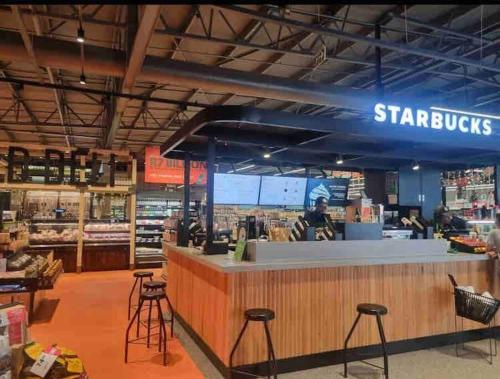 una tienda Starbuck con taburetes y un mostrador en Luxury 1bed Serengeti OliveWood ORT Airport, en Kempton Park