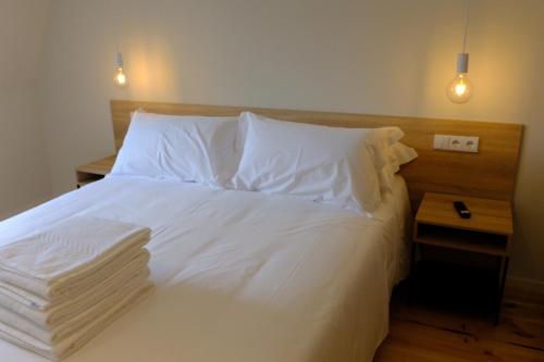 a bedroom with a white bed with white sheets and pillows at Liberator Rossio in Lisbon
