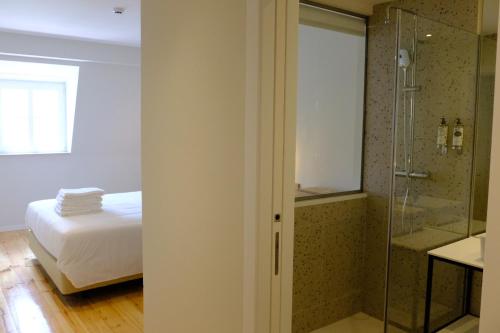 um quarto com uma cama e uma cabina de duche em vidro em Liberator Rossio em Lisboa