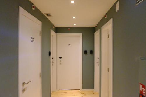 a hallway with white doors and green walls at Liberator Rossio in Lisbon