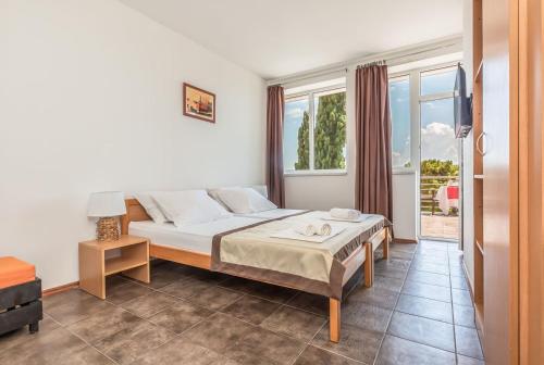 ein Schlafzimmer mit einem Bett und einem großen Fenster in der Unterkunft Motel Ljetni raj in Baška Voda