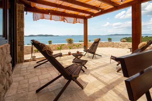 eine Terrasse mit Stühlen und Meerblick in der Unterkunft Lea Apartments in Drage