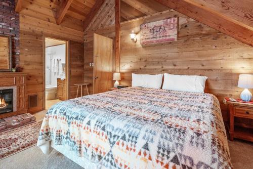 1 dormitorio con 1 cama en una cabaña de madera en The Lakehouse Cabin - Located close to the Lake! Hot Tub, Smart TV, and WiFi! en Big Bear Lake