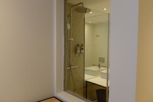 a bathroom with a glass shower and a sink at Liberator Rossio in Lisbon