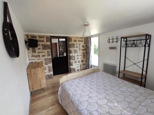 una camera con un letto in una stanza con pareti in pietra di Aux Berges du Mont a Pontorson