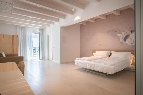 カオルレにあるUnico Hotel Caorleのベッドルーム1室(ベッド1台付)、リビングルームが備わります。
