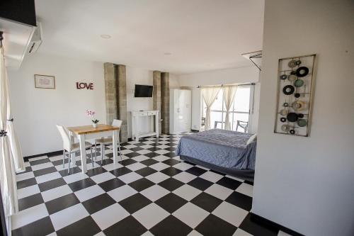 um quarto com piso em xadrez, uma cama e uma mesa em La vie en rose em San Bernardo