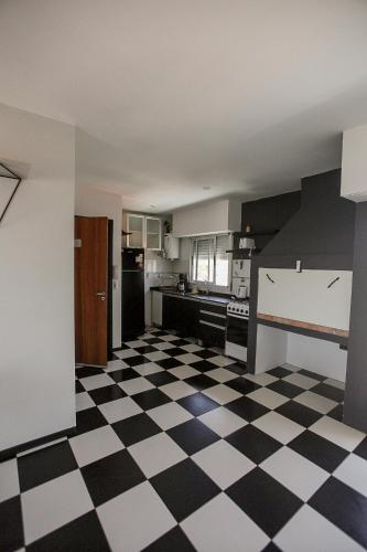 a kitchen with a black and white checkered floor at La vie en rose in San Bernardo