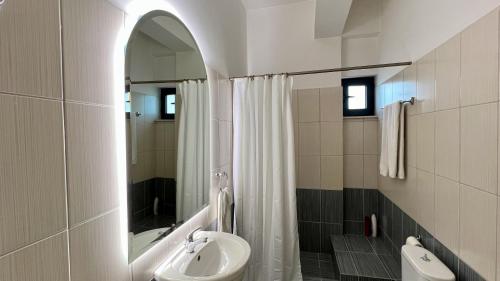 a bathroom with a sink and a shower with a mirror at 100 meters from the sea in Xylokastron