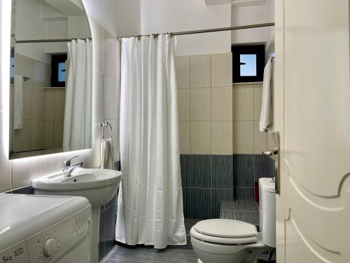bagno bianco con servizi igienici e lavandino di 100 meters from the sea a Xylokastron