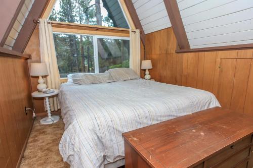 a bedroom with a bed and a large window at The Getaway - Amazing and cozy escape! With beautiful views of the Bear Mountain slopes! in Big Bear Lake